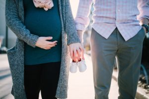 זוג הורים בהריון מחזיקים ידיים